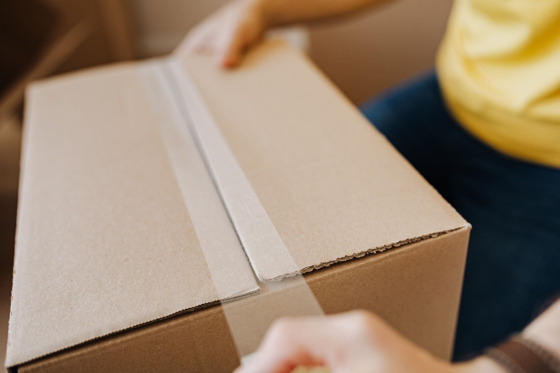 Person holding a cardboard parcel
